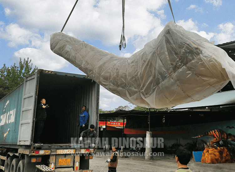 The giant dinosaur model is disassembled and loaded